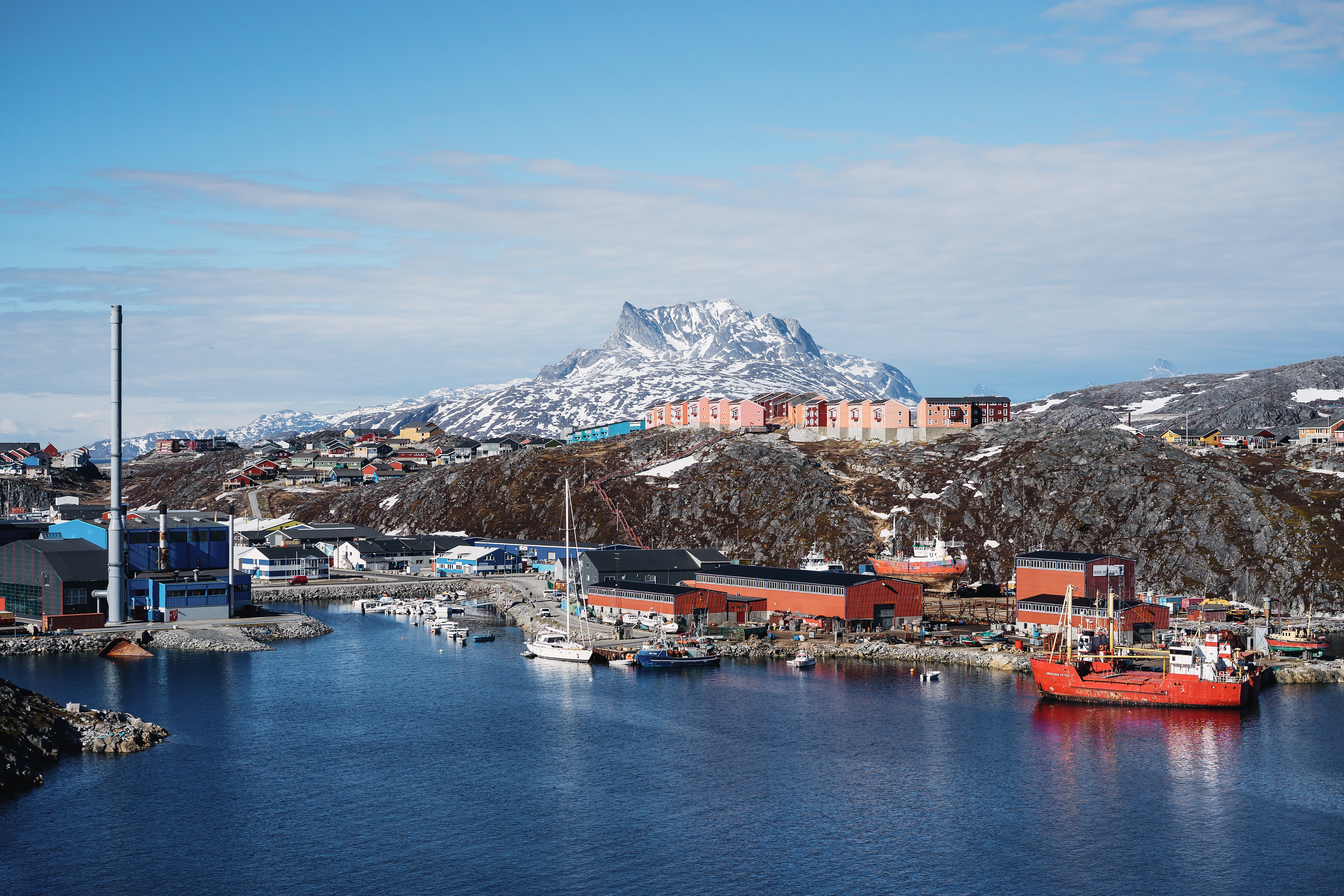 boats in the harbor of a small arctic town